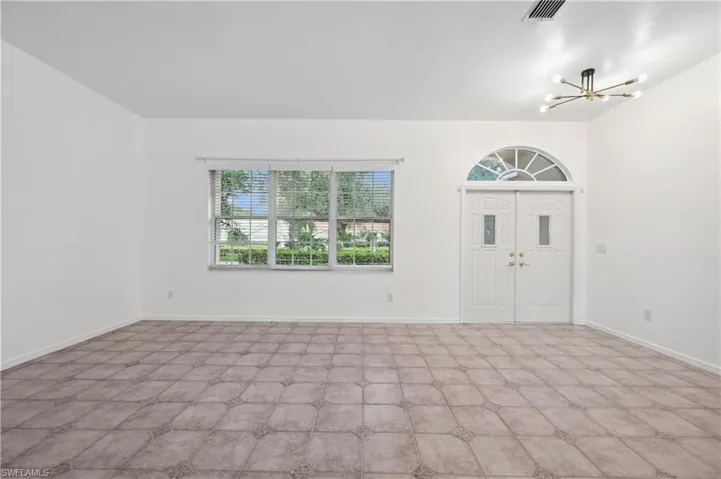 Entryway featuring a chandelier and baseboards