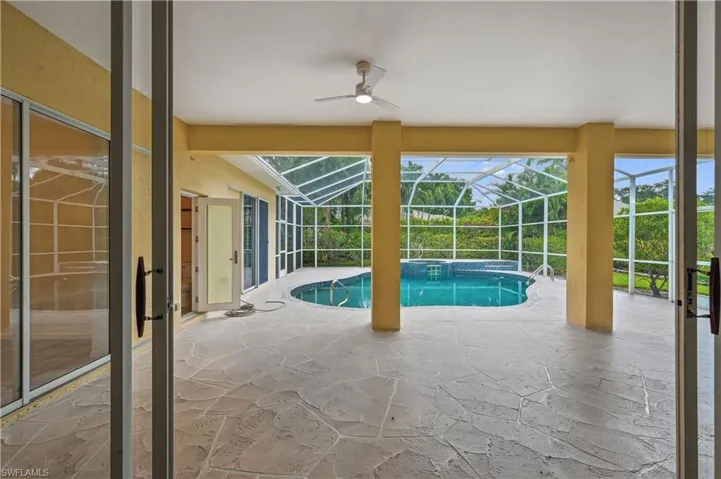 View of swimming pool with a patio area, a sunroom, ceiling fan, glass enclosure, and a pool with connected hot tub