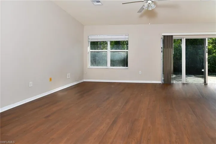 Empty room with baseboards, wood finished floors, and ceiling fan