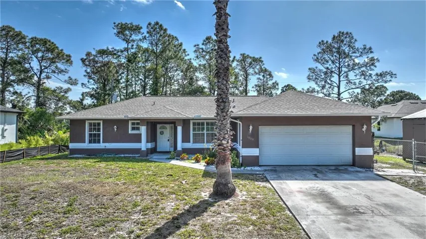 Ranch-style home with stucco siding, an attached garage, fence, and concrete driveway