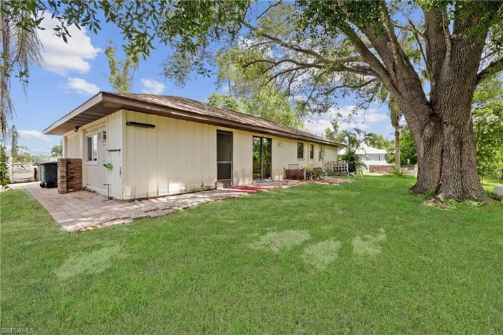 Rear view of property featuring a yard and a patio area