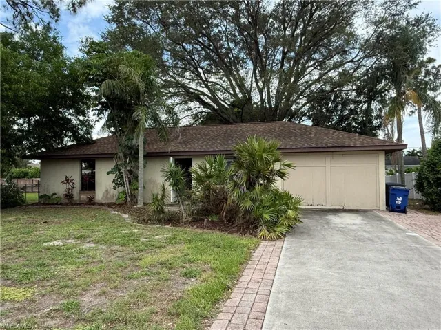 Ranch-style home with driveway, roof with shingles, and stucco siding