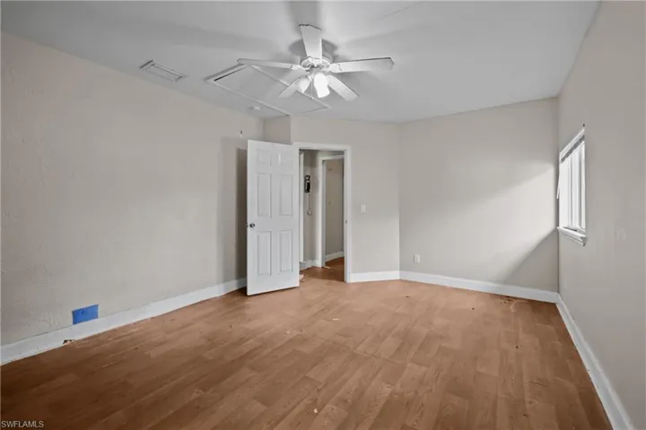 Spare room featuring attic access, ceiling fan, and light wood-style floors