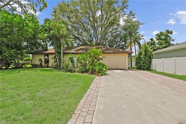 View of front facade with stucco siding and driveway