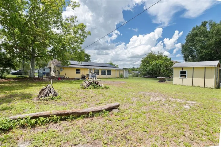 View of grassy yard featuring an outbuilding