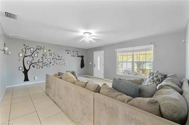 Living room featuring a ceiling fan and light tile patterned floors