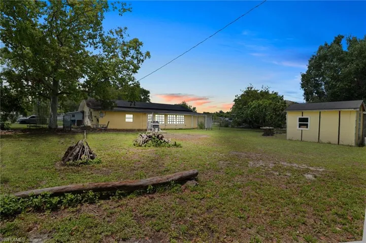 Yard at dusk featuring a yard and a storage shed