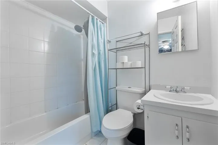 Full bath with shower / bath combo with shower curtain and vanity