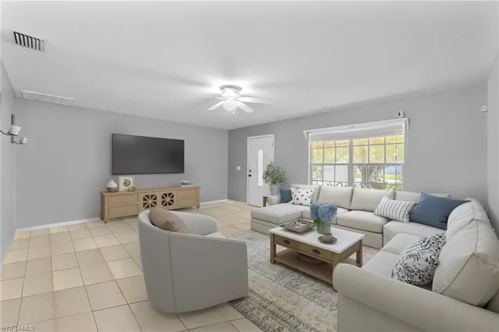 Living area with a ceiling fan and light tile patterned floors