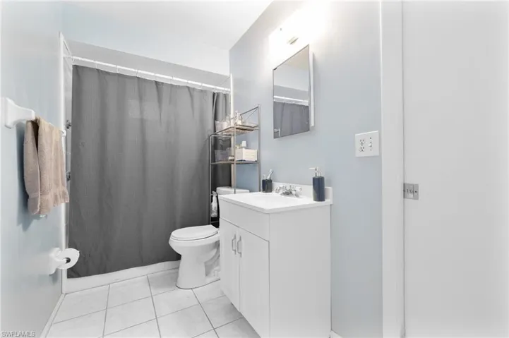 Full bathroom featuring vanity, tile patterned floors, and curtained shower