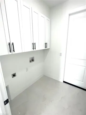 Washroom with washer hookup, hookup for an electric dryer, cabinets, and light tile floors