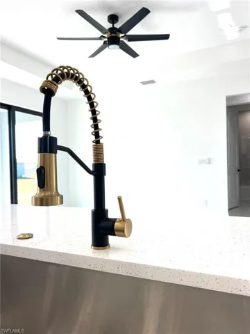 Room details with light stone countertops and ceiling fan