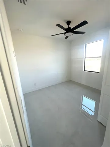 Unfurnished room featuring ceiling fan and concrete flooring
