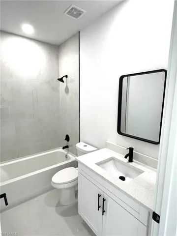 Full bathroom featuring vanity, toilet, and tiled shower / bath combo