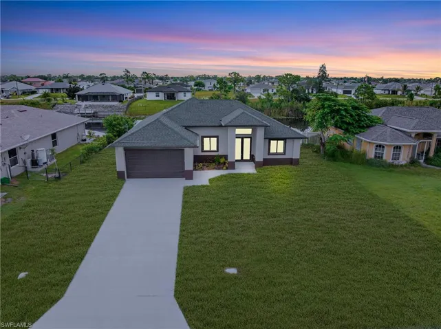 View of front of home featuring a residential view, driveway, stucco siding, and a shingled roof