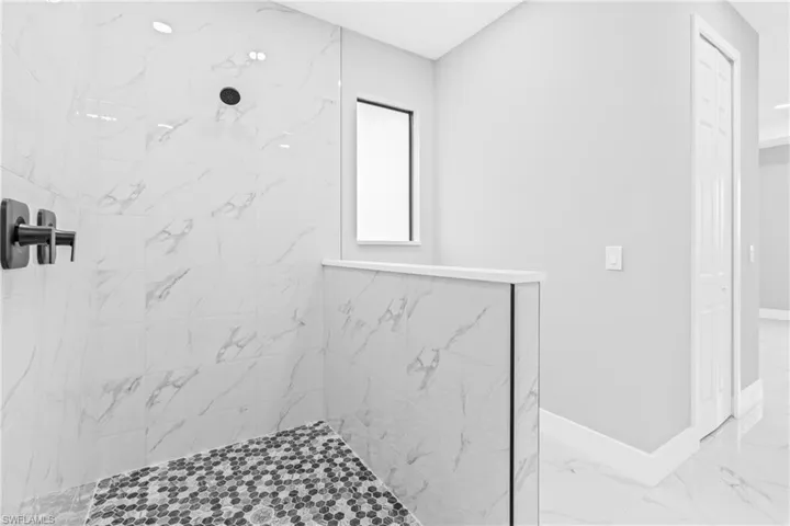 Full bathroom featuring a marble finish shower and marble finish flooring