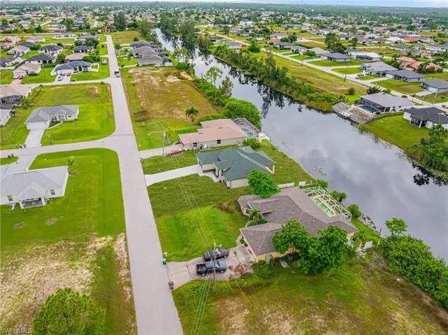 Aerial perspective of suburban area featuring a nearby body of water