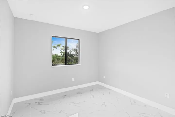 Spare room with light marble finish floors and baseboards