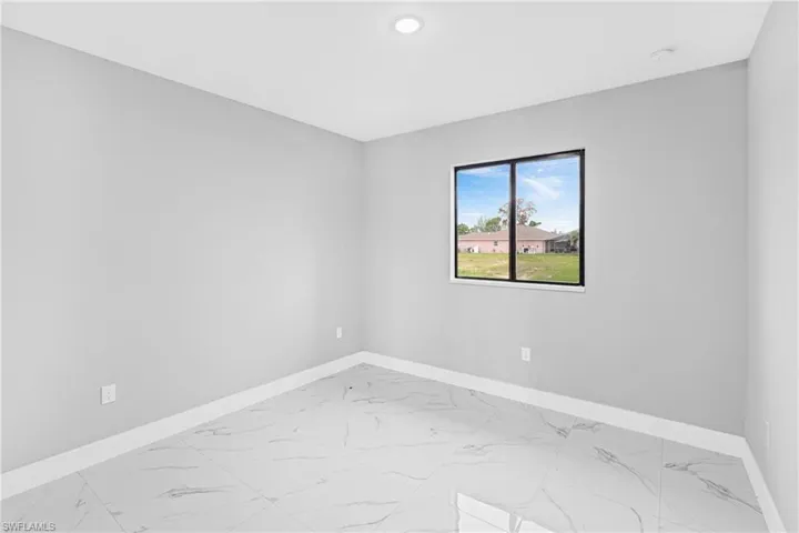 Unfurnished room featuring light marble finish flooring and recessed lighting