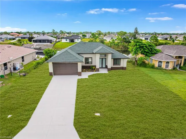 View of front of property with a residential view, concrete driveway, stucco siding, and a garage
