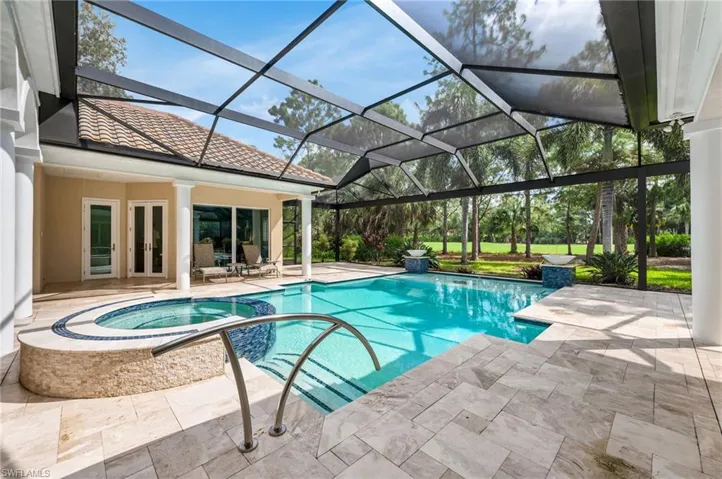 View of pool featuring an in ground hot tub, screen enclosure, and a patio area