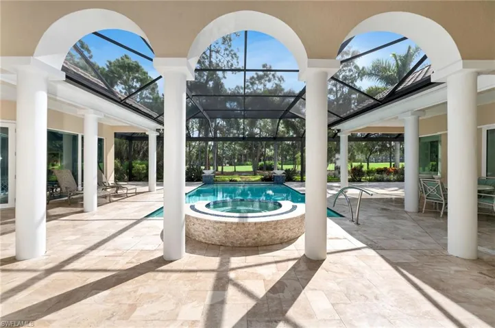 View of patio / terrace featuring picture frame screen enclosure and a pool with hot tub