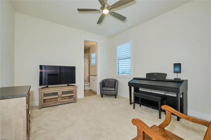 Sitting room/Bedroom Adjacent to POOL BATH  with light carpet and ceiling fan