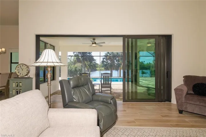 Great Room with open sliders to Lanai & Pool and view of POND
