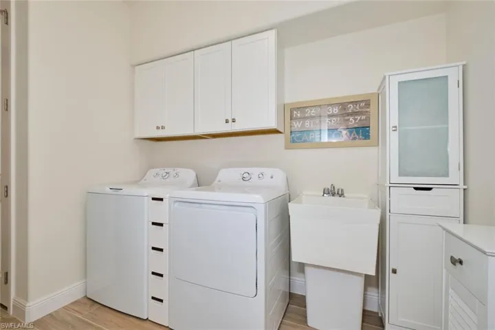 Laundry room featuring lots of storage cabinets, washer and Dryer