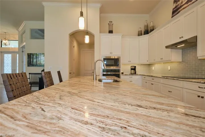 Kitchen with 42" upper cabinets, granite countertops, under counter lighting, and breakfast bar