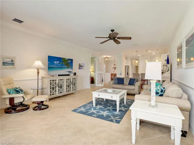 Living Area with Tile Flooring on the Diagonal, Crown Molding, Chair Rails, Ceiling Fan, Entrance to Den/Flex Room, Kitchen, & Dining Area