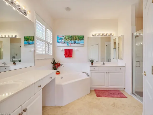 Primary En-Suite Bathroom with Dual Vanities & Cultured Marble Countertops, Dual Medicine Cabinets, Tub, Walk-In Shower with Glass Enclosure, & Plantation Shutters