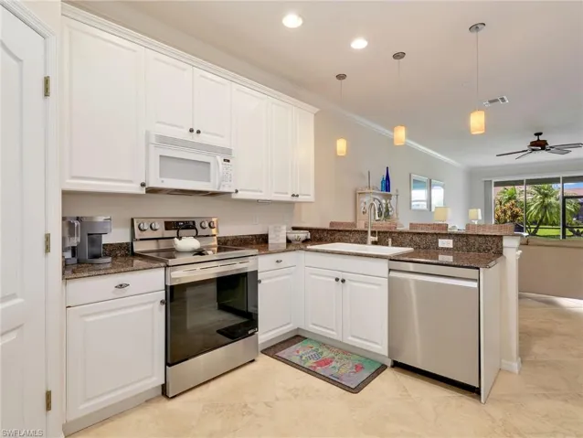 Kitchen with Crown Molding, Stainless Steel Appliances & White Microwave