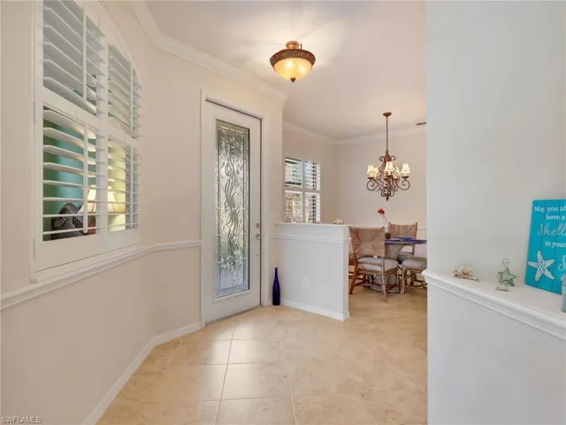 Clear Stained Glass Front Door Entry and Dining Area with Crown Molding and Chair Rail, Just Behind Is The Guest Bedroom & Bathroom And Laundry Room