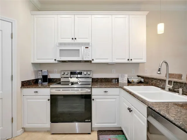 Kitchen with Crown Molding, LG Stainless Steel Range, White Microwave, Double Sink, & Granite Countertops