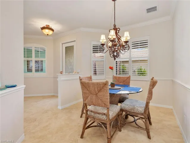 Front Entryway and Dining Area with Crown Molding, Chair Rail, & Chandelier