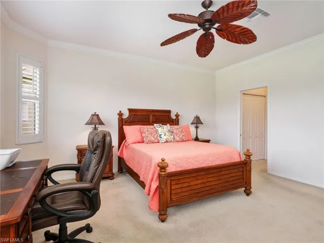 Primary Bedroom with Crown Molding, Plantation Shutters, Ceiling Fan, & Entrance Into En-Suite Bathroom