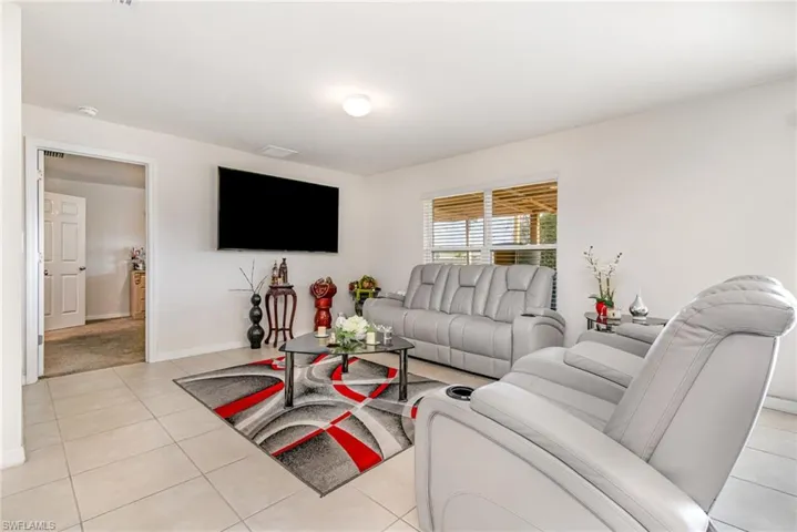 Living area with baseboards and light tile patterned flooring
