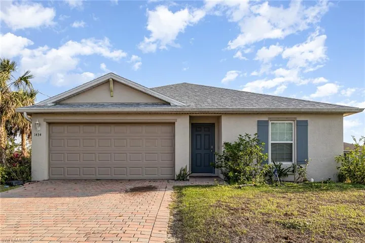 Single story home featuring decorative driveway, roof with shingles, an attached garage, and stucco siding