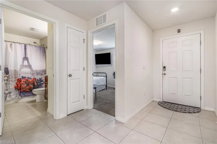 Foyer entrance with light tile patterned flooring, visible vents, and baseboards