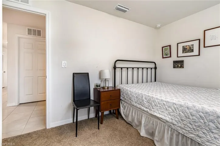 Bedroom featuring light colored carpet, visible vents, baseboards, and light tile patterned floors