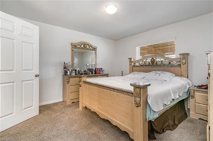 Bedroom with light carpet and baseboards