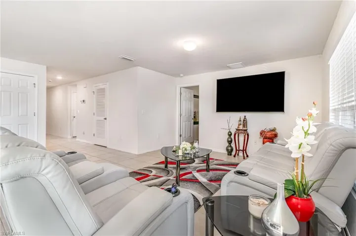Living room featuring visible vents, baseboards, and light tile patterned floors