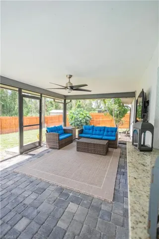Fenced backyard featuring a ceiling fan, an outdoor living space, and a patio area