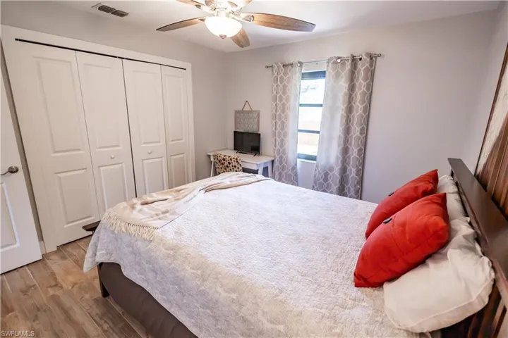 Bedroom featuring wood finished floors, a closet, and a ceiling fan