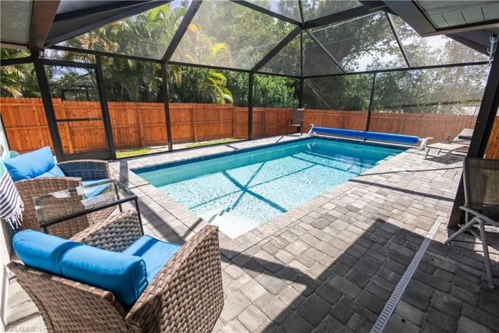 View of pool featuring a fenced backyard, glass enclosure, a sunroom, and a patio area