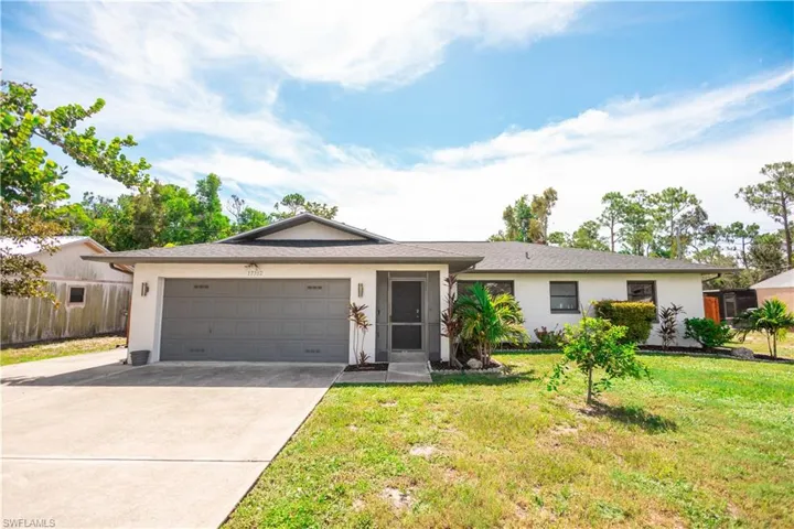Single story home with stucco siding, driveway, and a garage