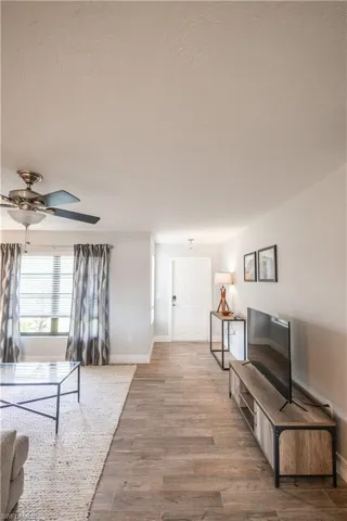 Living room featuring light wood-style flooring and a ceiling fan