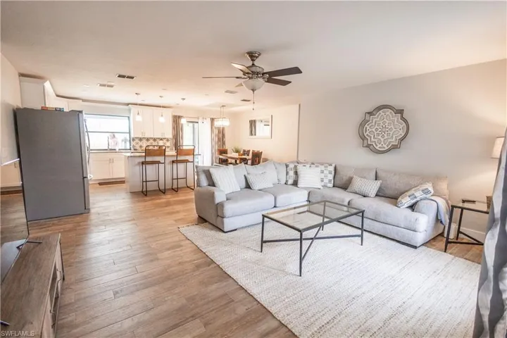 Living area with light wood finished floors and a ceiling fan