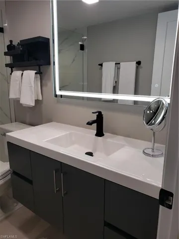 Full bath with toilet, walk in shower, and vanity